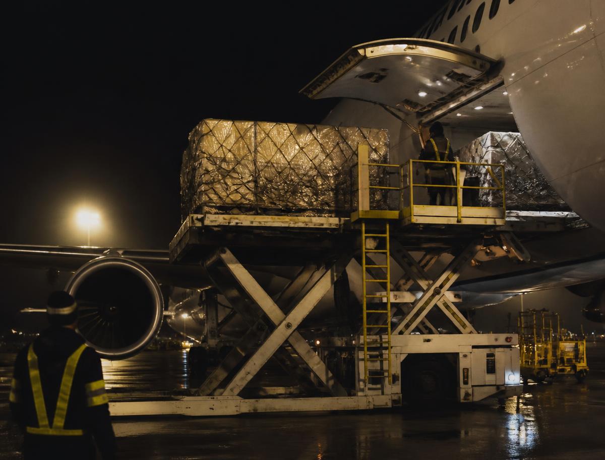 Luftfracht wird nachts in ein Frachtflugzeug verladen
